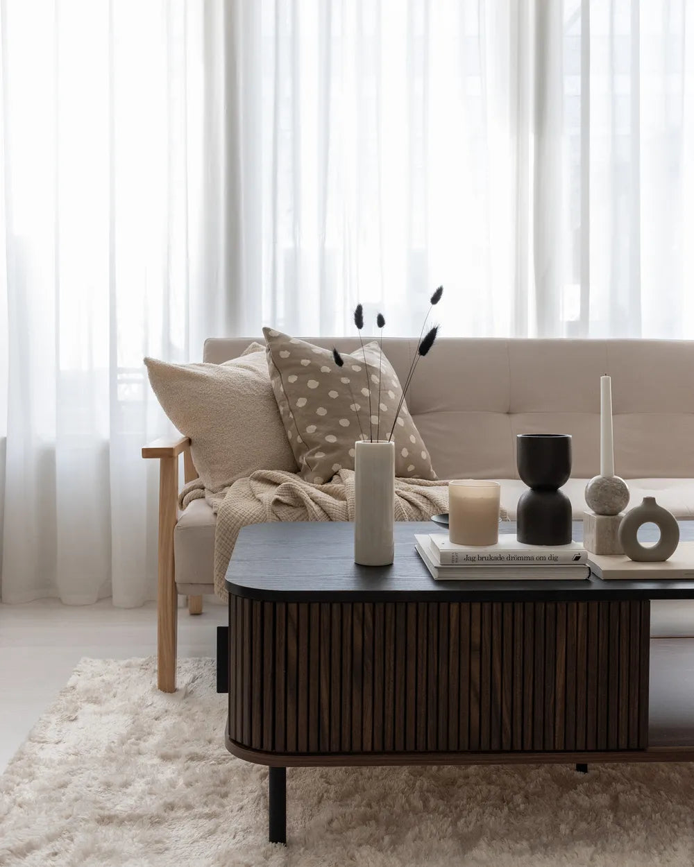 The JOSE dark brown coffee table is a rectangular coffee table with built-in storage, designed for modern living rooms. It features sliding doors that provide easy access to concealed storage compartments, as well as two open shelves for everyday items.